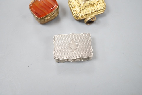 A Victorian engraved silver shaped rectangular vinaigrette, Alfred Taylor, Birmingham, 1850, 27mm and two other gilt metal vinaigrettes, one with inset agate lid.